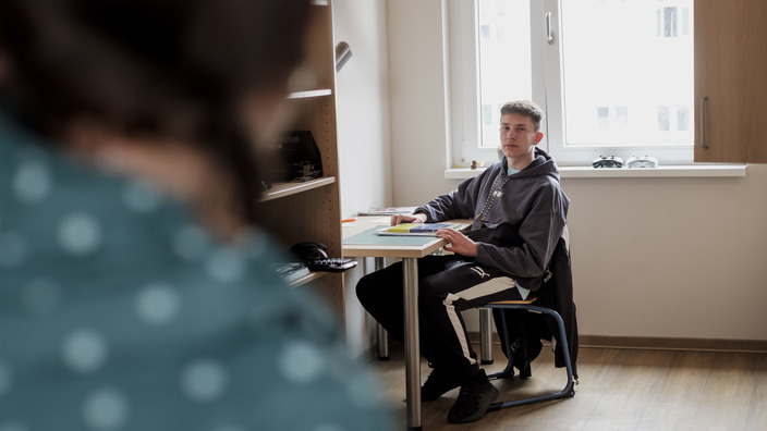 Schüler am Schreibtisch in seinem Internats-Zimmer