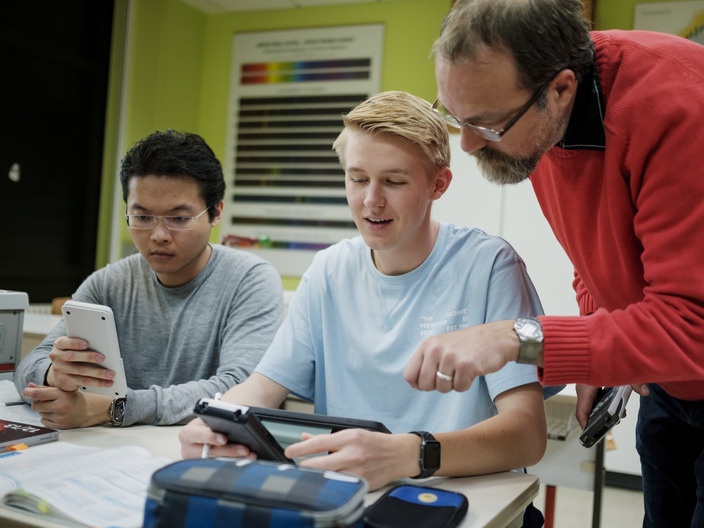 Zwei Schüler mit Lehrer im Unterricht