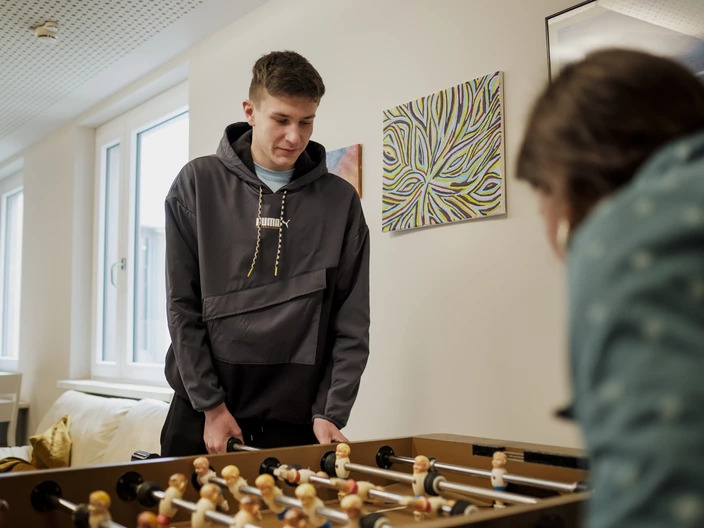Schüler spielt Kicker mit Betreuerin