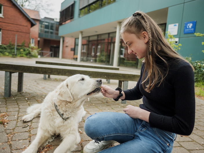 Schülerin mit Schulhund vor dem CJD Gymnasium Braunschweig 